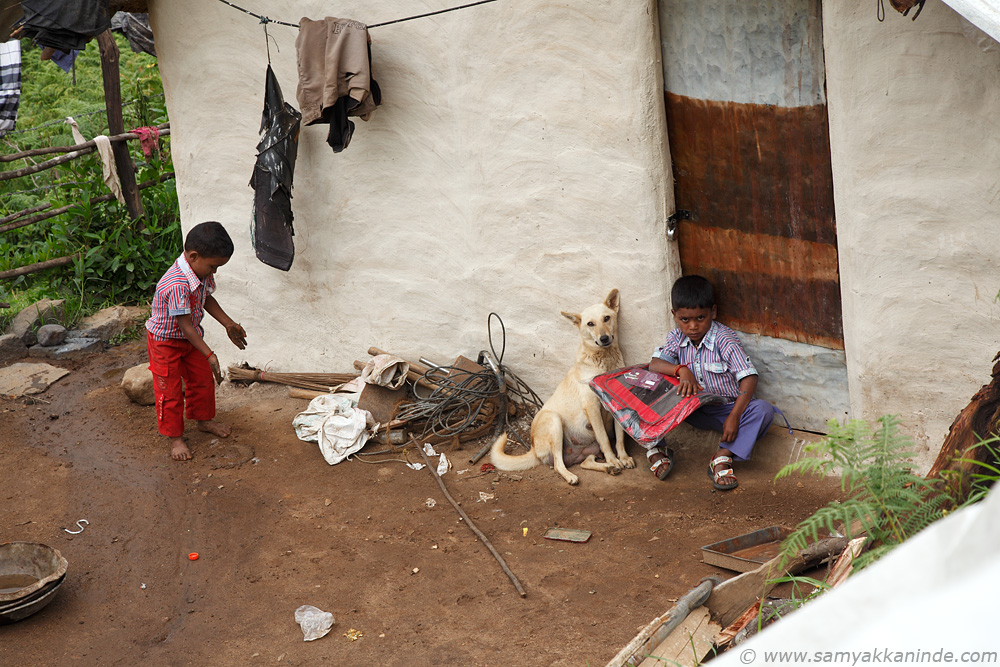 The kids were waiting at the close door for their parents to return from the field work/farms